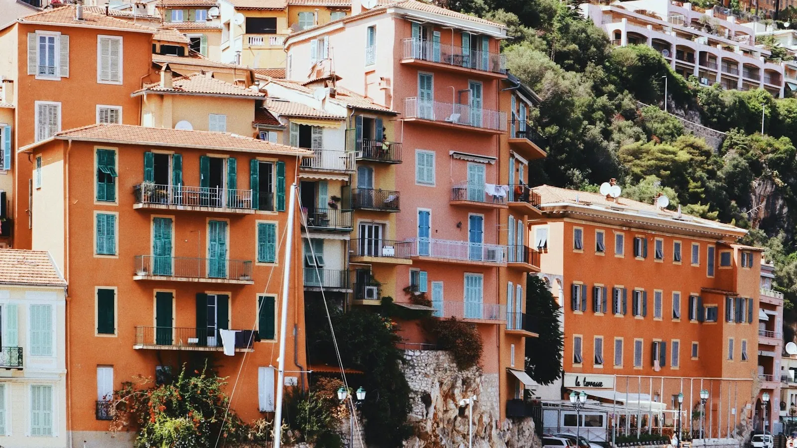 Terracotta waterfront apartment buildings and moored sailboats at Villefranche-sur-Mer on the French Riviera